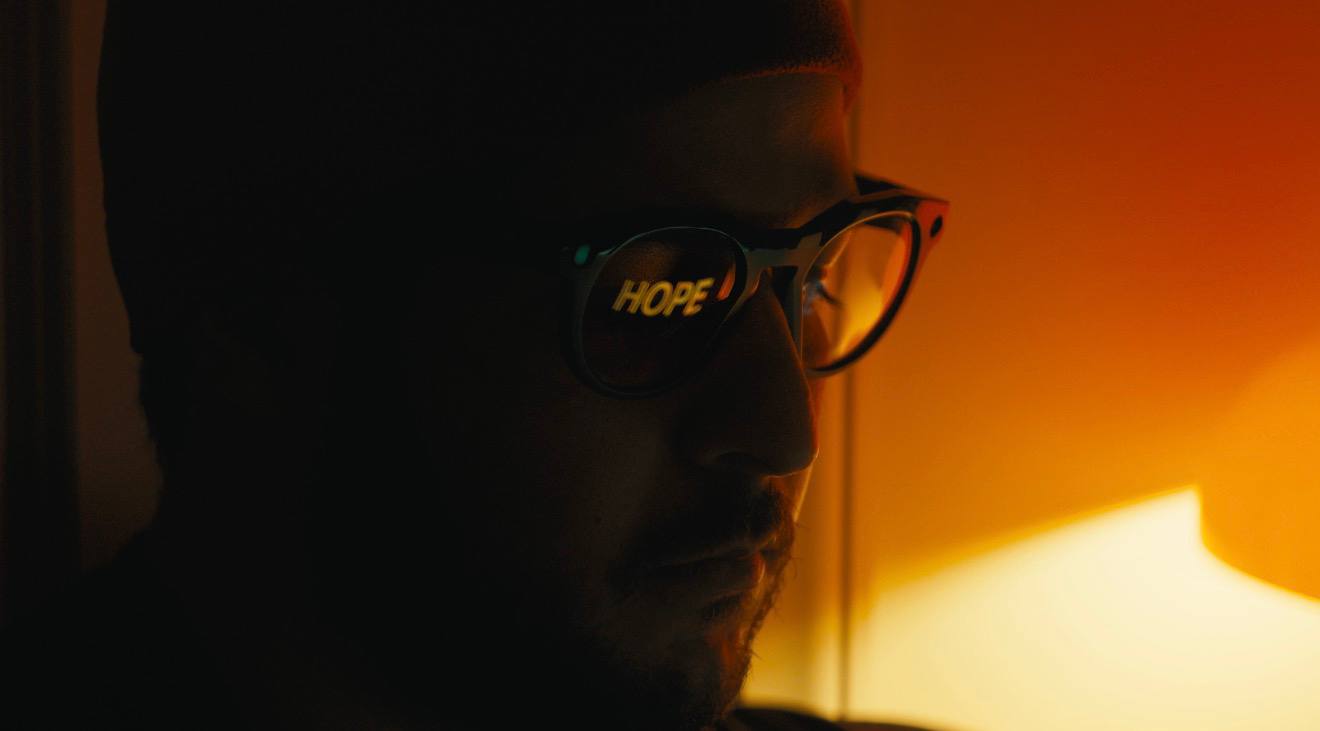 HOPE reflected in sunglasses, lit by warm neon