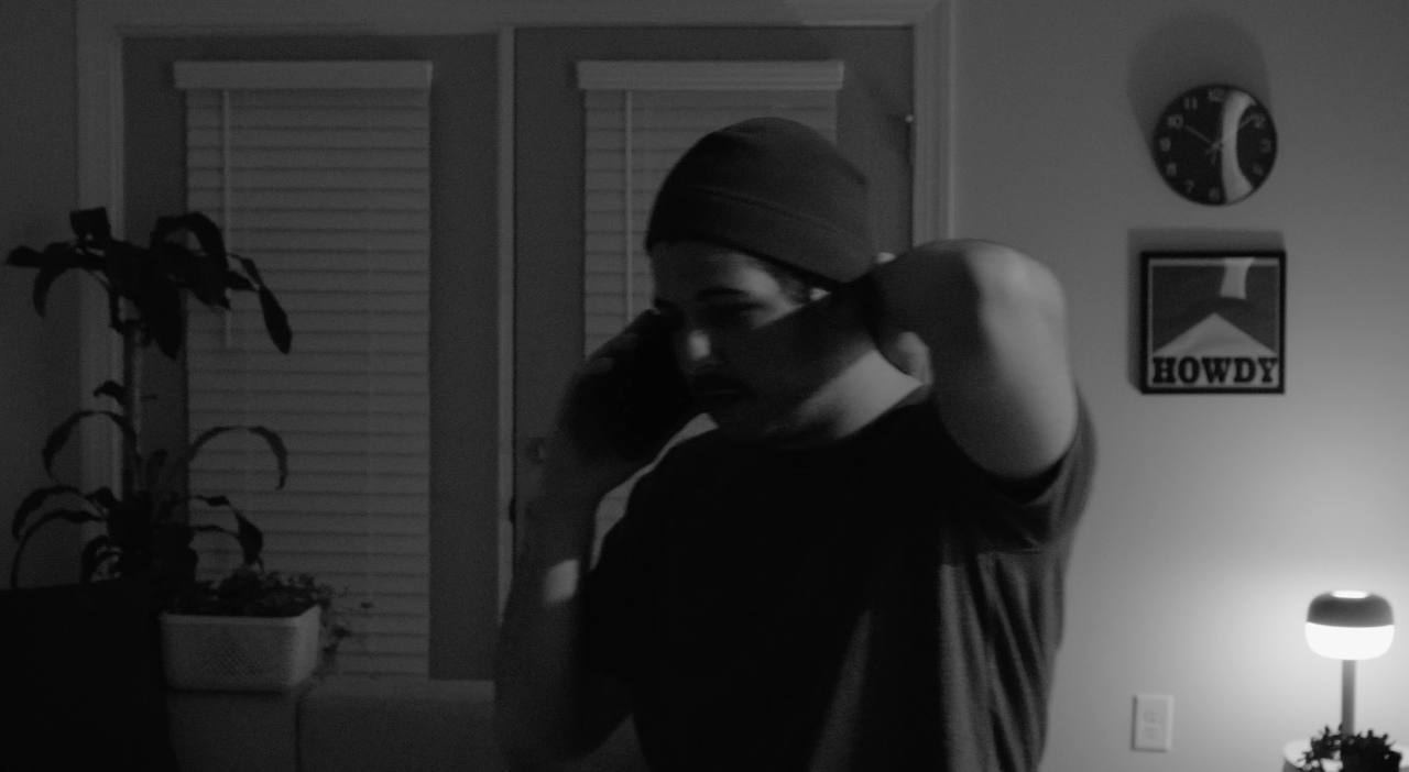 Black and white portrait, subject in a beanie on the phone